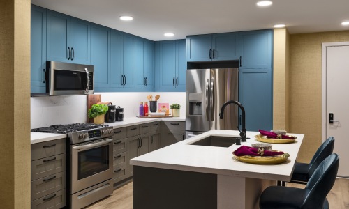 Spacious and well lit kitchen with stainless steel appliances and dark accents 