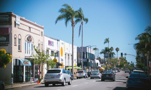 a street with cars and palm trees